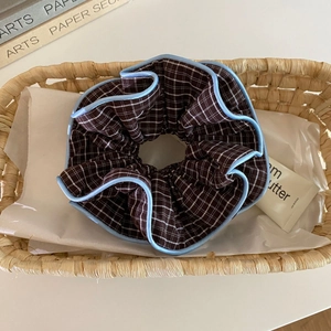 Nahaufnahme von Retro-Karo-Haargummi mit blauem Paspel-Detail und weichem Faltenstoff