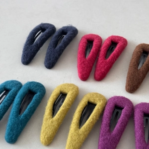 Gros plan de barrettes colorées en feutre en forme de goutte avec texture laineuse