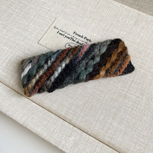 Close-up of retro woven knit hair clip with colorful wool texture and vintage style