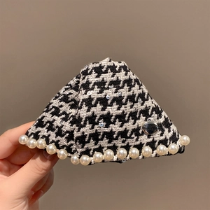 Détail de la pince à cheveux pied-de-poule avec perles et bouton argenté gravé