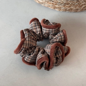 Detailed view of grey plaid fabric scrunchie with soft brown plush velvet edge trim