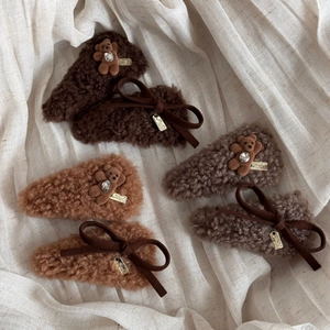 Detailed view of plush bear hair clips with rhinestone accents and elegant bows