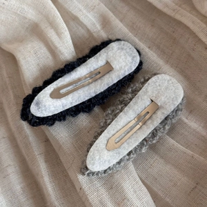 Detailed back view of handmade wool knit drop-shaped BB hair clips in black and light grey