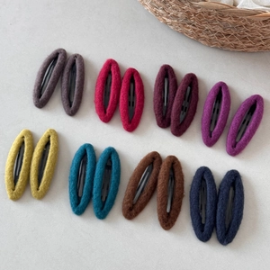 Close-up of 8-color oval felt hair clips set in wool texture for autumn and winter styling