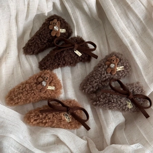 Detailed view of plush teddy bear hair clips and velvet bows in warm brown tones