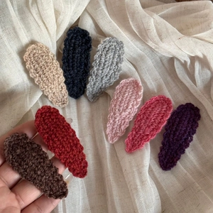 Close-up of handmade crochet wool hair clips in eight assorted solid colors for autumn