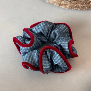 Detailed shot of blue striped scrunchie with red velvet trim and fine stitching