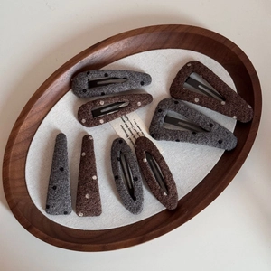 Detail of wool felt polka dot hair clips set in a wooden tray for autumn styling