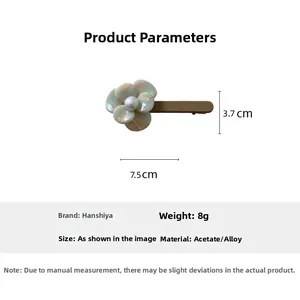 Detail view of acetate flower hair clip with dimensions 7.5cm x 3.7cm and pearl center