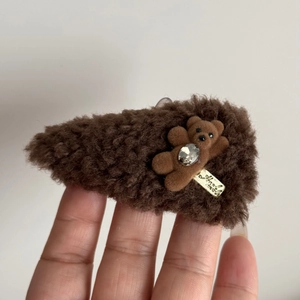 Detail of plush brown triangle hair clip with cute flocking bear and sparkly rhinestone