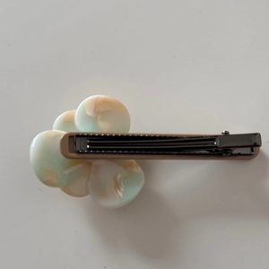 Detailed view of translucent flower hair clip with green and orange gradient petals