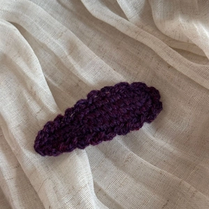 Detail of dark purple crochet wave edge hair clip showing knit wool texture