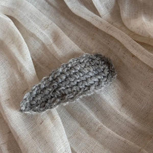 Detailed macro view of dark grey handmade knit wave texture on the woolen hair clip