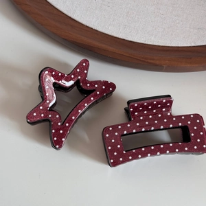 Détail des pinces à cheveux rouges à pois et paillettes en forme d'étoile et rectangle