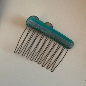 Detail of teal acetate hair comb with colorful stones and eleven sturdy metal tines