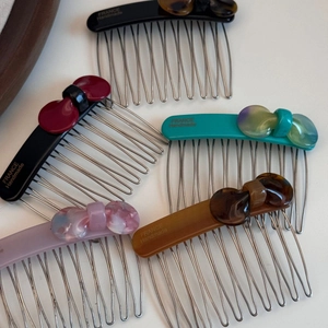 Detailed view of handmade acetate bow hair combs with vintage marble and tortoiseshell patterns