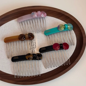 Set of five elegant acetate bow hair combs with marble patterns and metal teeth