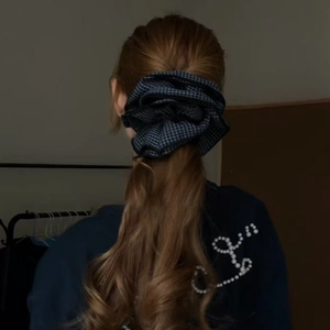 Blue and black checkered oversized fabric scrunchie styled on a low ponytail