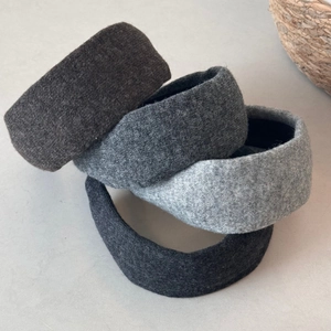 Detailed view of four thick knit headbands in grey and black wool texture