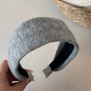 Detail showing soft grey knitted texture and wide padded design of the winter headband