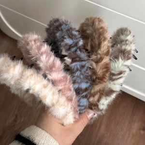 Close-up of five plush faux fur hair claws in leopard, pink, and striped patterns