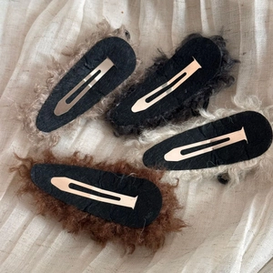 Detailed back view of four plush bow hair clips with metal duckbill snap fasteners