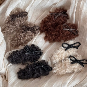 Detail of four faux shearling hair clips in beige and brown with chic PU leather bows