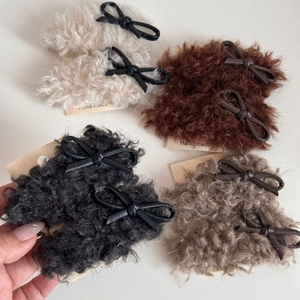 Detailed view of faux fur hair clips with PU leather bows in multiple colors on cards