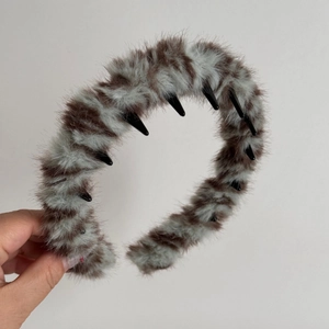 Detailed close-up of the plush tiger pattern headband featuring a black plastic inner comb