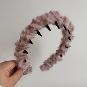 Detail of plush dusty rose headband featuring non-slip black toothed comb for hair fixing