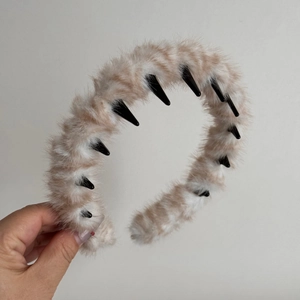 Detailed view of plush headband showing tiger striped faux fur and black plastic inner teeth