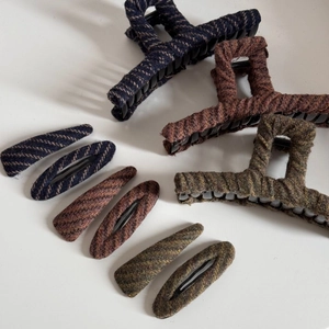 Detail of tweed fabric hair clips and shark claws in blue, brown, and green