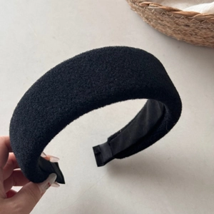 Close-up of black padded wool headband showing thick sponge and anti-slip lining