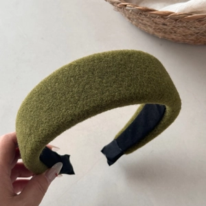 Detail shot of a thick grass green wool headband with a soft matte fuzzy texture