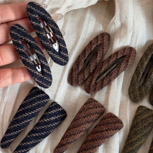 Detail of vintage striped tweed hair clips set with oval and triangle textured metal grips