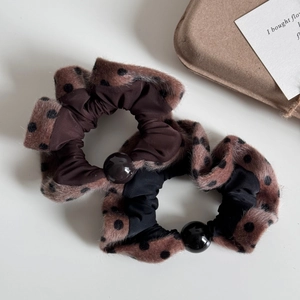 Close-up of plush polka dot hair scrunchies with elegant pearl decorative accents