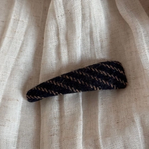 Detailed view of large vintage tweed wrapped shark hair claw clip in brown and black stripes
