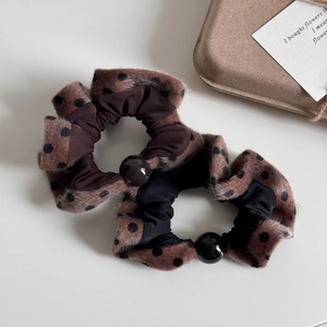 Close-up of plush polka dot hair scrunchies with large pearl beads in a vintage style