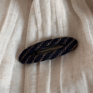 Close-up of vintage blue striped tweed fabric texture on a large elegant hair claw clip