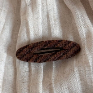 Close-up of vintage striped tweed fabric texture on a large hair claw clip for women