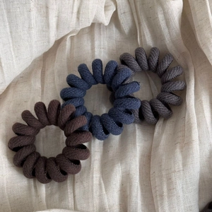 Three-pack spiral fabric phone cord hair ties in brown, navy blue, and grey colors