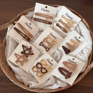 Set of acetate hair clips in star and eyewear shapes on handmade cards in a basket