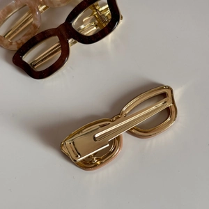 Detail of tortoise shell acetate hair clip in trendy sunglasses shape with metal duckbill clip