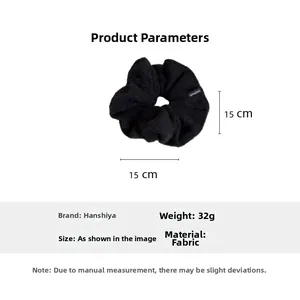 Vue détaillée du chouchou géant en peluche noire avec étiquette et mesure de 15 cm