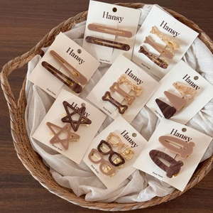 Set of assorted acetate hair clips with marble patterns in a stylish woven basket