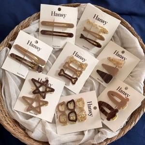 Detail of assorted acetate star and sunglasses shaped hair clips on a white card display