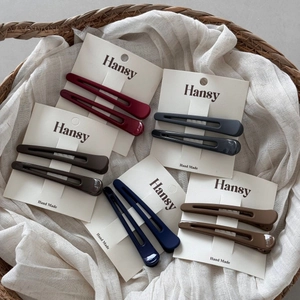 Cinq paires de barrettes à cheveux minimalistes de couleurs variées sur carte blanche