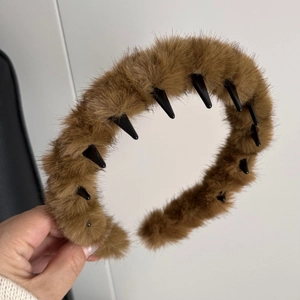 Détail d'un serre-tête marron en peluche montrant la texture douce et les dents de maintien