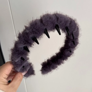 Détail du serre-tête ondulé en peluche montrant les dents et la texture fausse fourrure