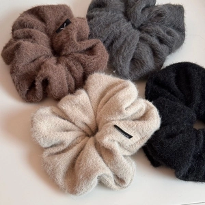 Texture détaillée de chouchous géants en peluche dans un tissu aspect mohair neutre